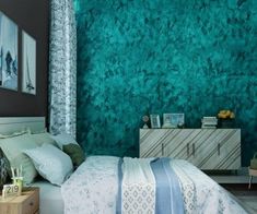 a bedroom with green wallpaper and white bedding in front of a blue accented wall