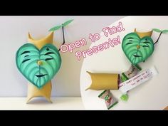 an open - to - find presents banner with two green heart shaped masks hanging from strings