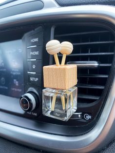 an air vent in the car with two wooden sticks sticking out of it's holder