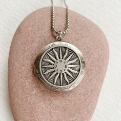 "This beautiful silver locket features a full sun with compass directions in the center. It will become a special addition to your jewelry collection. The locket is 33mm in diameter, smooth brass, and opens for a secret place to keep pictures, messages, or whatever you like. The locket has a stainless steel rolo chain with a lobster clasp. You may choose 18\", 20\", 24\", or 30\" length. The backside of the locket is smooth and shiny. This locket can hold two 25mm inserts (about one inch.) I wil Compass Design Medallion Pendant Necklace Gift, Medallion Pendant Necklace With Compass Design For Gift, Vintage Compass Pendant Jewelry, Gift Compass Design Round Pendant Medallion Necklace, Round Pendant Medallion Necklace With Compass Design For Gift, Gift Medallion Necklace With Compass Design, Personalized Spiritual Medallion Necklace, Bohemian Engraved Round Locket Necklace, Medallion Necklace With Compass Design For Gift