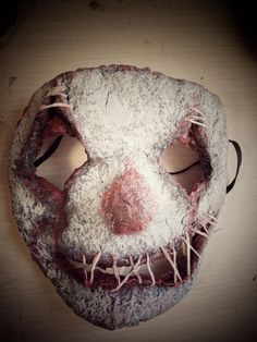 a creepy mask with white and red paint on it