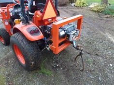 an orange tractor parked on top of a dirt road