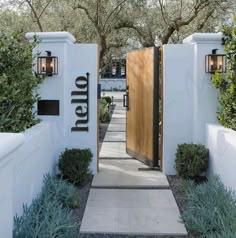 an entrance to a home with trees and bushes surrounding the entryway is lit by lanterns