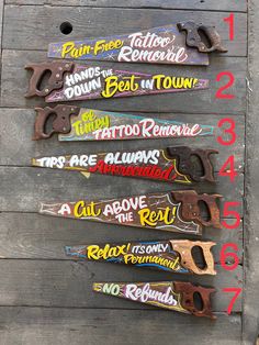 four pairs of skis with different designs on them sitting next to each other in front of a wooden wall