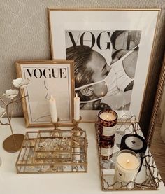 a table topped with candles and pictures next to a candle holder on top of a table