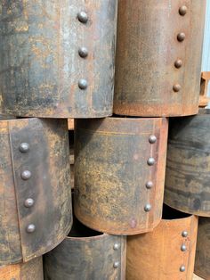 several metal buckets stacked on top of each other with rivet holes in them