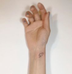 a person's arm with a small elephant tattoo on the left side of their wrist