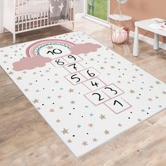 a baby's room with a pink rug that has numbers and stars on it