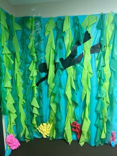 an ocean scene made out of green paper and blue streamers with fish on it