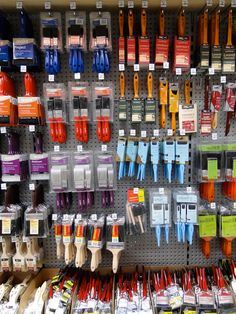 there are many different colors of toothbrushes on the wall in this store display