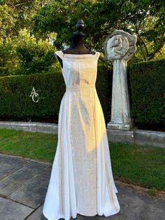 a dress on display in front of some bushes