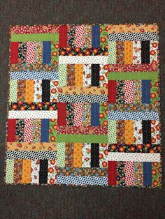 a patchwork quilt is displayed on the floor