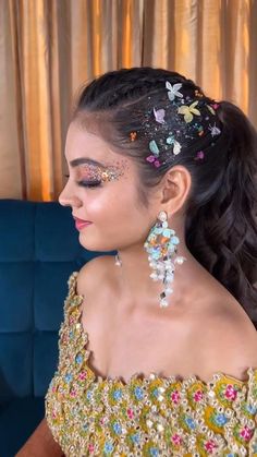 a woman in a gold dress with butterfly decorations on her head and hair pulled back