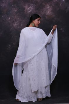 This beautiful hand embroidered chikankari kurit embellished with mukaish work along with heavy flare garara set is a must-have this season. Made from pure georgette fabric and hand embroidered all over, it is sure to make you stand out in the crowd. Kurti length- 44-48 inches. Garara size- Free size can fit upto size 48. Customisation- Dyeable in any colour. Add an order note with the shade number to get the set dyed in any specific colour you want without any extra charges. Traditional Drape Mulmul Palazzo Set For Wedding, Traditional Georgette Palazzo Set With Cutdana, Traditional Cutdana Georgette Palazzo Set, Traditional Mulmul Sharara With Resham Embroidery, Traditional Mulmul Sharara With Sheer Dupatta, Eid Sharara With Cutdana On Georgette, Eid Sharara In Georgette With Cutdana, Eid Georgette Sharara With Cutdana, Traditional Drape Sharara With Sheer Dupatta