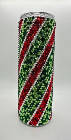 a spool of red, green and white sequinized ribbon on a roll