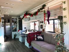 a living room filled with furniture and christmas decorations on the wall next to a window