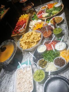 a buffet table filled with lots of different types of food and dips on trays