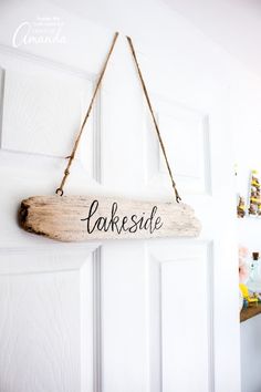 a wooden sign hanging from the side of a door that says lakesidee on it