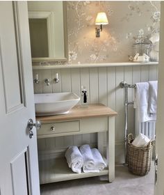 a bathroom with a sink, mirror and towel rack next to the door that is open