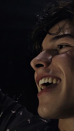 a close up of a person holding a cell phone to his ear and smiling at the camera