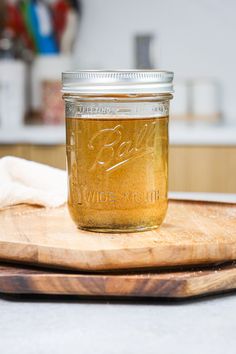 a glass jar filled with liquid sitting on top of a wooden cutting board