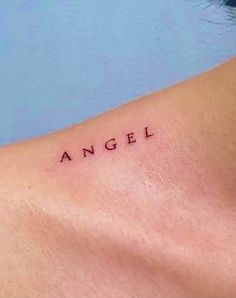 an angel tattoo on the back of a woman's neck with words above it