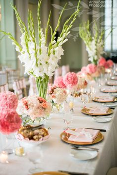 flowers are in vases on the table at a wedding reception, with candles and place settings