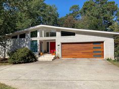 a white house with wood garage doors and windows