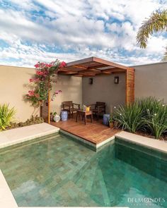 a small pool in the middle of a patio with a table and chairs next to it