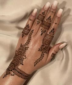 a woman's hand with henna tattoos on it