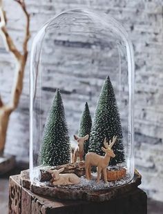 a snow globe with deer and trees under it