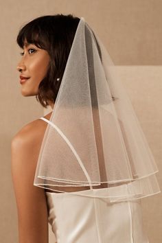 a woman wearing a wedding veil and looking off to the side