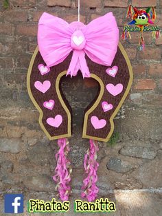 a pink and brown door hanger with hearts in the shape of a horse's head