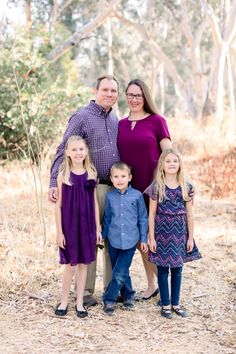 a family posing for a photo in the woods