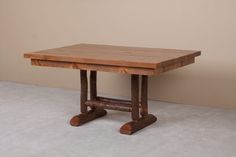 a small wooden table with two legs on the top and one leg up against the wall