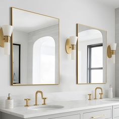 a bathroom with two sinks and mirrors on the wall