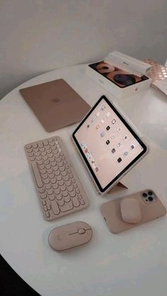 there is a tablet, keyboard and mouse on the table with other items around it