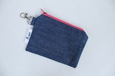 This coin purse or small zipped pouch is made from  blue denim.  The lining is a white cotton fabric featuring small pink, orange, lilac and blue flowers.  The purse also has a metal lobster clasp attached for added security - attach it to your keys, your lanyard or the inside of your bag.  The purse measures 14cm x 10.5cm. Blue Rectangular Coin Purse With Zipper Pocket, Blue Coin Purse With Zipper Closure As Gift, Rectangular Blue Coin Purse With Zipper Pocket, Casual Blue Coin Purse For Gift, Casual Blue Coin Purse Perfect For Gifts, Denim Coin Purse, Small Zipper Pouch, White Cotton Fabric, Purse Pouch