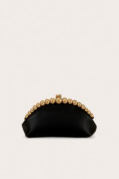 A handheld clutch crafted from leather with circular gold beads and a clasp closure. — Smooth leather — Circular gold bead details — Clasp closure — Handheld design Black And Gold Clutch, Black Clutch Purse, Clutch Purse Black, Gold Clutch, Clutch Black, Evening Sandals, Swimming Bag, Fancy Bags, Black Clutch