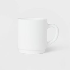 a white coffee cup sitting on top of a table