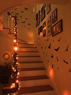 the stairs are decorated with halloween decorations and lite - up candles, as well as pictures on the wall