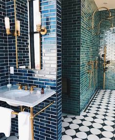 a bathroom with green and white tiles on the walls