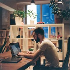 a man sitting at a table using a laptop computer