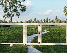 an open gate in the middle of a grassy field with a path going through it