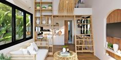 a living room filled with furniture next to a tall wooden shelf covered in plants and potted plants