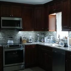 a kitchen with dark wood cabinets and stainless steel appliance on the counter top