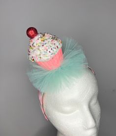 Sprinkles cupcake in pink glitter wrapper with cherry on top - blue/aqua  tulle - 1 inch wide white satin headband striped with pink ribbon  Lightweight and comfortable  One size fits most Whimsical Party Supplies For Birthday And Carnival, Novelty Adjustable Headband For Birthdays, Pink Novelty Party Hair Accessories, Pink Novelty Hair Accessories For Party, Cute Birthday Headband Hair Accessories, Fun Pink Headband For Birthday, Whimsical Pink Headband For Birthday, Cute Pink Party Headband, Cute Pink Party Hair Accessories