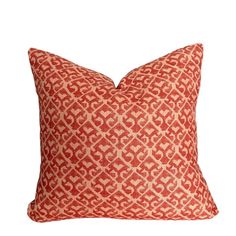 a red and white pillow with an intricate design on the front, sitting on a white background