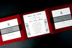 two red and white wedding cards in a box on a black table with silver trim