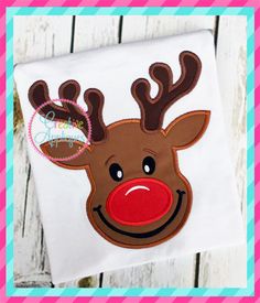 a reindeer face with red nose and antlers on a white shirt